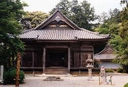 木々に覆われた近長谷寺本堂の前に砂利の庭園がある写真