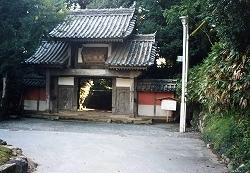 中央に入り口があり、2段の瓦葺屋根がある山門（法泉寺）の写真