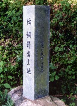 伝 銅鐸出土地と彫られた長方形の石碑の写真