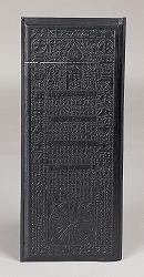 黒い板に模様が彫られている丹生暦の版木の写真