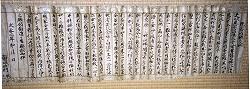 白い縦に折り目のついた長い紙に漢字がつらつらと書かれている現当所願之状の写真