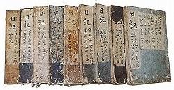 日記と書かれた古びた冊子が9冊ほど並べられている写真