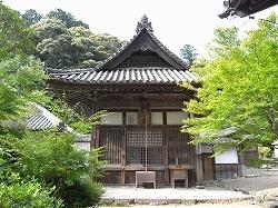 木々に囲まれた入母屋造り、本瓦葺の神宮寺護摩堂の写真