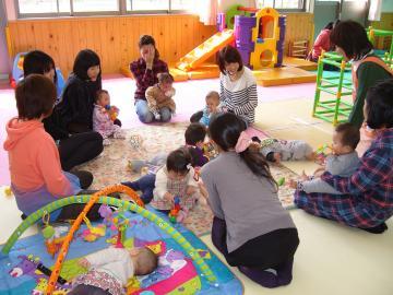 児童館でお母さん達と赤ちゃん達が集まって触れ合っている写真